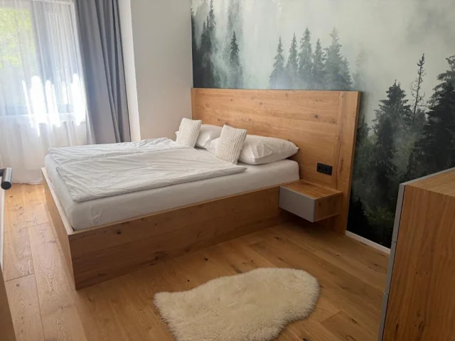 Samostatná ložnice s manželskou postelí a lesním motivem